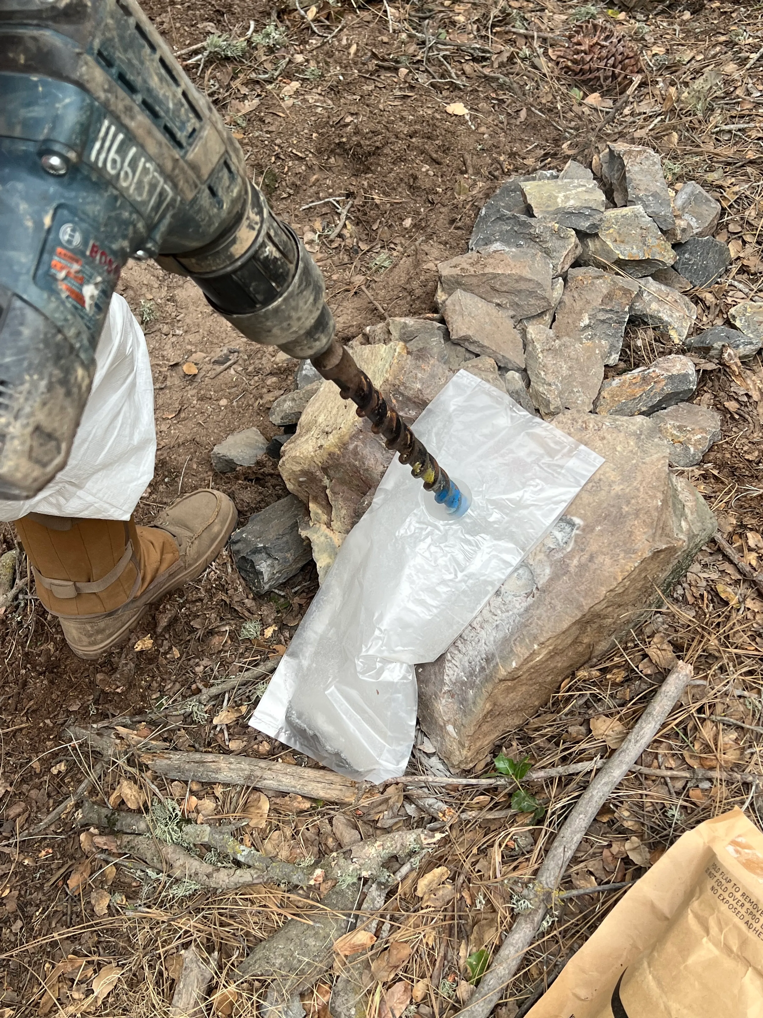 Drilling a rock chip to collect a sample in the field.